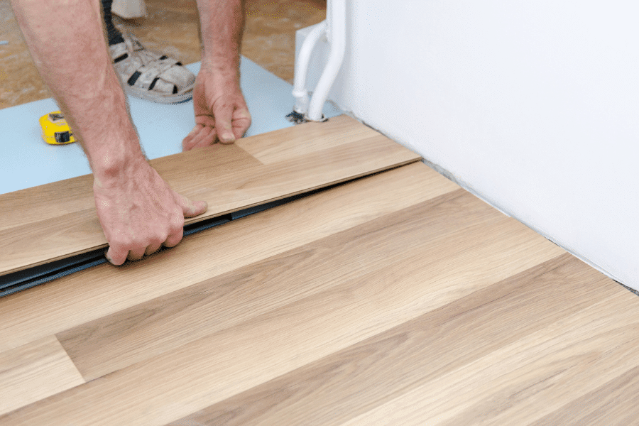 man's hands installing a hardwood flooring